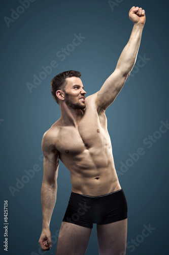 Plakat Przystojny mężczyzna robi mięśniom