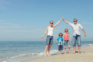 Wall Mural - Happy family standing on the beach at the day time.