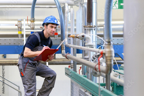 Fotografie, Obraz Industriearbeiter untersucht Anlage in Fabrik