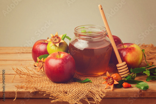 Obraz w ramie Honey, apple and pomegranate on wooden table