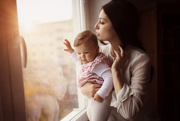 beautiful young mother holding her cute little daughter