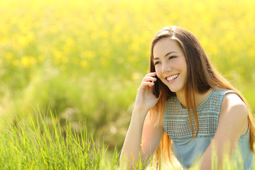 Poster - Woman calling on the mobile phone in a green field