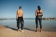 Young athletes standing on beach preparing for triathlon