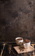 Cup with coffee beans at dark wooden background