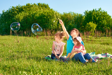 Wall Mural - Mother with her two daughters in a park