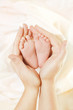Baby Newborn Feet in Mother Hands. New Born Kid Foot