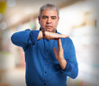© asierromero - portrait of a mature man dong a time out gesture