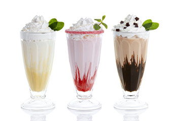 Wall Mural - Three glasses of milkshakes, bananashake, chocolateshake and fruiteshake cocktails