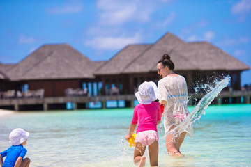 Wall Mural - Two little girls and happy mother playing on summer vacation