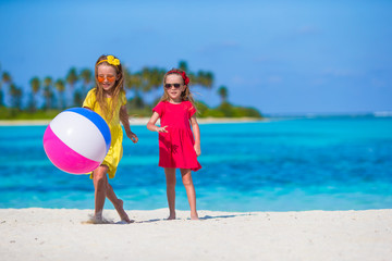 Wall Mural - Little adorable girls playing on beach with ball