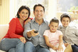 © Monkey Business - Young Hispanic Family Watching TV At Home