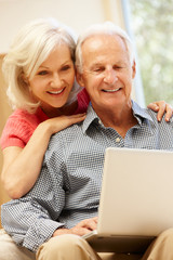 Wall Mural - Senior man and daughter using laptop