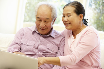 Wall Mural - Senior Asian couple using laptop