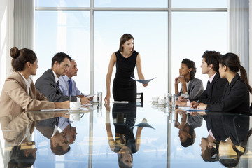 group of business people having board meeting around glass table