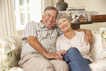 Wall Mural - Retired Senior Couple Sitting On Sofa At Home Together