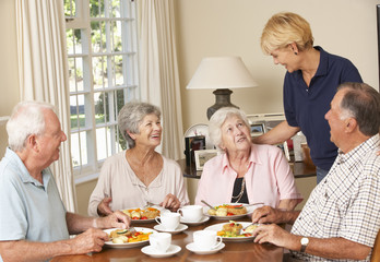 Sticker - Group Of Senior Couples Enjoying Meal Together In Care Home With Home Help