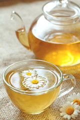 Wall Mural - Cup of camomile tea with chamomile flowers and teapot