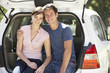 © Monkey Business - Couple Sitting In Trunk Of Car