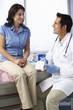 © Monkey Business - Doctor In Surgery With Female Patient Writing Prescription