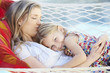 © Monkey Business - Mother And Daughter Relaxing In Garden Hammock Together