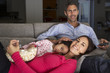 © Monkey Business - Hispanic Family On Sofa Watching TV And Eating Popcorn