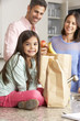 © Monkey Business - Family Unpacking Grocery Shopping In Kitchen