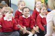 © Monkey Business - Pupils Sitting On Mat Listening To Teacher