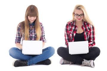 Wall Mural - two teenage girls sitting with laptops isolated on white