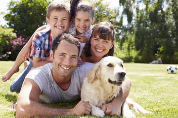 Canvas Print - Family Relaxing In Garden With Pet Dog