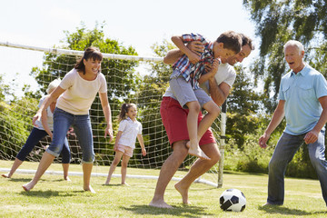 Canvas Print - Multi Generation Playing Football In Garden Together