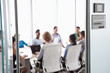 © Monkey Business - View Through Door Of Conference Room To Business Meeting