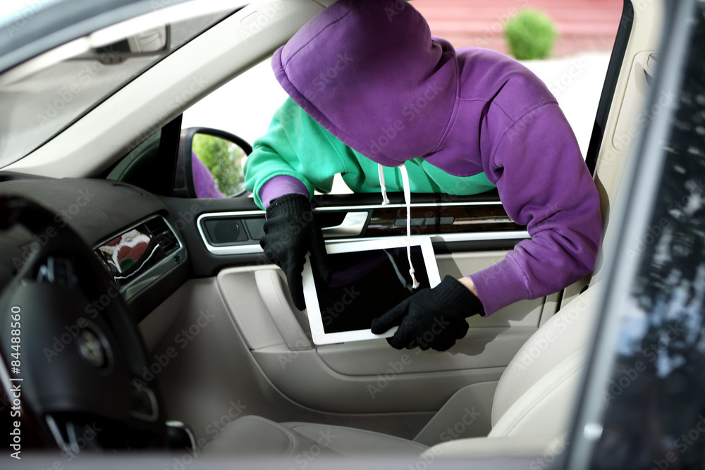 Man burglar steals the tablet of car