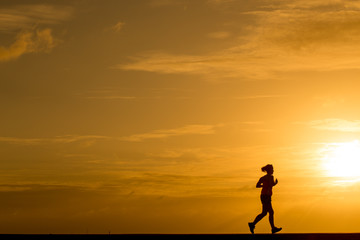 Wall Mural - Silhouette women jogging at sunset