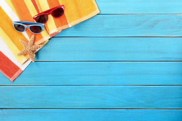 Beach background border with old blue wood deck decking sunglasses and sunbathing towel summer holiday vacation photo