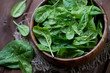 Wooden bowl with fresh spinach leaves, close-up, high angle view