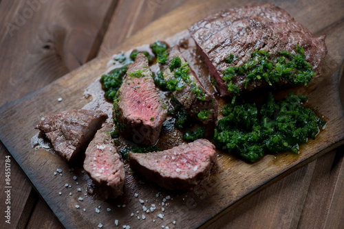 Medium rare grilled beef steak with chimmichurri sauce, close-up Poster