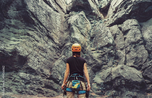 Cuadros en Lienzo Mujer escalador de pie delante de una piedra al aire libre de la roca