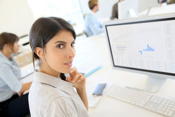 Wall Mural - Portrait of young brunette woman working in office