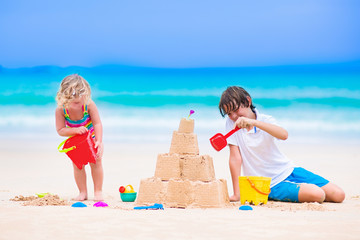 Wall Mural - Kids building sand castle on a beach