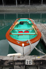 Wooden Rowboat Docked At A Pier