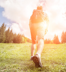 Wall Mural - man with backpack climb up to the hill