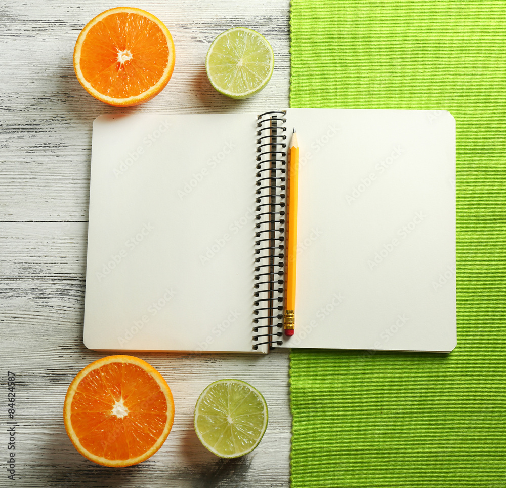 Open recipe book, napkin on wooden background