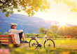 canvas print picture - woman relaxing beside her e-bike - e-power 05