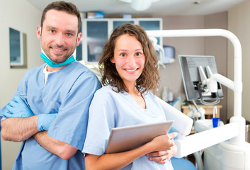 Portrait of a young attractive dentist and his assistant in his