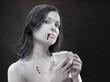 Kobieta pomalowana na biało z krwią na ustach i filiżanką w dłoniach