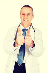 Wall Mural - Portrait of confident male doctor with thumbs up