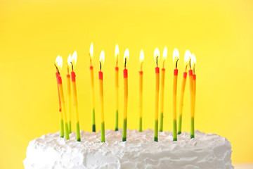 Birthday cake with candles on color background