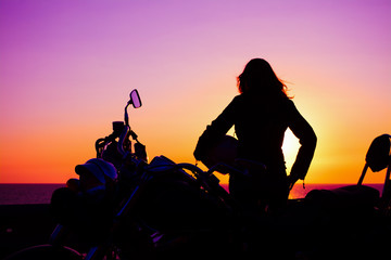 girl and classic motorcycle at sunset