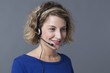 focused young woman using headset for answering phone call