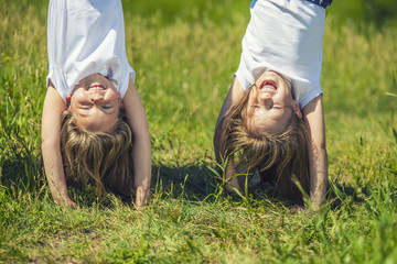 Children standing in a meadow on the hands